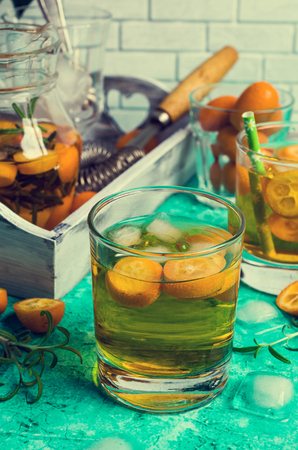 Transparent cold drink with citrus and rosemary on wooden background. Selective focus.の写真素材