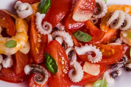 Salad with seafood and vegetables in a plate on the table. Selective focus.の写真素材