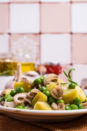 Octopus with vegetables in the plate on the table. Selective focus.の写真素材