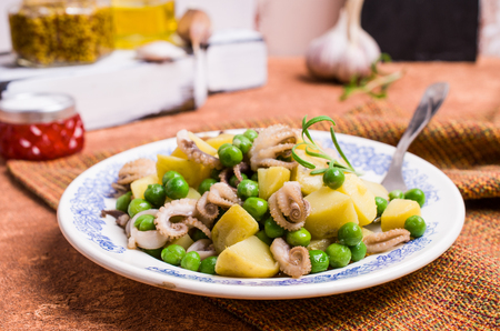 Octopus with vegetables in the plate on the table. Selective focus.の写真素材