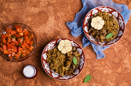 Rice with spices and meat with fried onions in a plate on the table. Selective focus.の写真素材