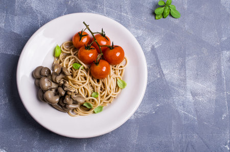 Brown paste with oyster mushrooms and tomatoes in a plate on the table. Selective focus.の写真素材