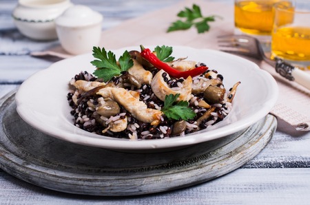 Rice mix with chicken and mushrooms in a plate on a wooden background. Selective focus.の写真素材