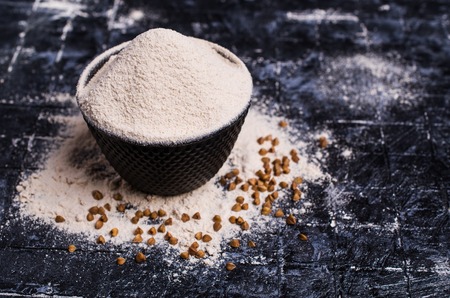Brown fine flour of buckwheat grains on the table. Selective focus.の写真素材