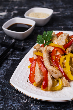 Fried slice of meat and pepper with sesame seeds on a stone background. Selective focus.の写真素材