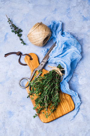 Branches of raw thyme on wooden cutting Board. Selective focus.の写真素材