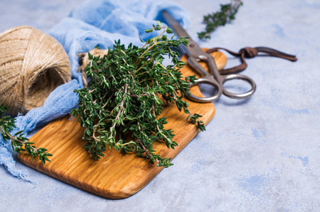 Branches of raw thyme on wooden cutting Board. Selective focus.の写真素材
