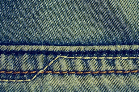 Denim texture with the effect of aging and scuffs. Grunge denim jeans fabric background. Abstract wallpaper with copy space.の写真素材