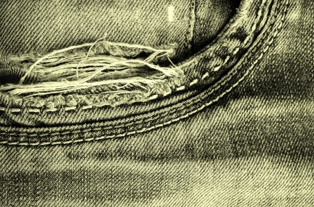 Denim texture with the effect of aging and scuffs. Grunge denim jeans fabric background. Abstract wallpaper with copy space.の写真素材