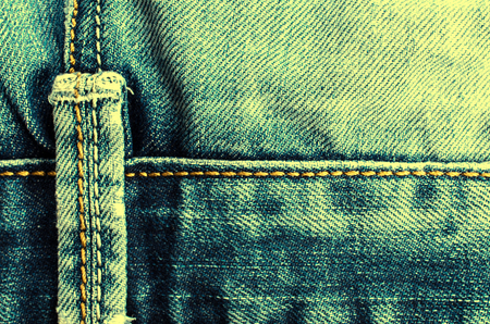 Denim texture with the effect of aging and scuffs. Grunge denim jeans fabric background. Abstract wallpaper with copy space.の写真素材