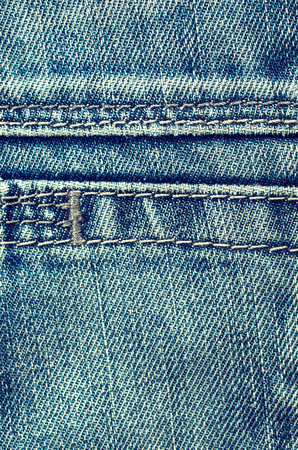Denim texture with the effect of aging and scuffs. Grunge denim jeans fabric background. Abstract wallpaper with copy space.の写真素材