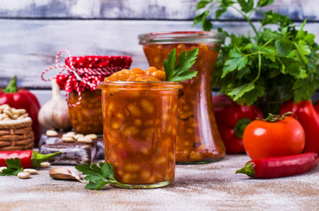 Canned beans with vegetables in tomato sauce on wooden background. Selective focus.