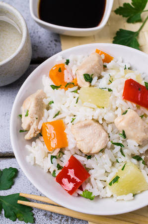 White rice with meat, pepper and pineapple in a plate on the table. Selective focus.の写真素材