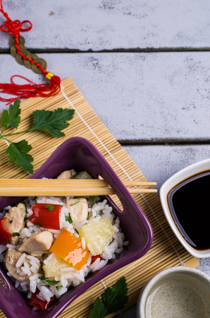 White rice with meat, pepper and pineapple in a plate on the table. Selective focus.の写真素材