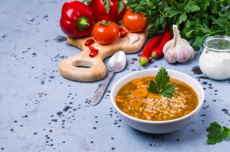 Traditional spicy soup with rice and vegetables in a plate on the table. Selective focus.の写真素材