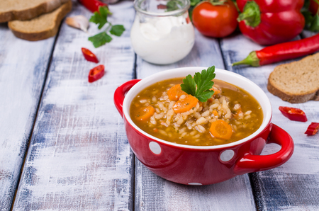Traditional spicy soup with rice and vegetables in a plate on the table. Selective focus.の写真素材