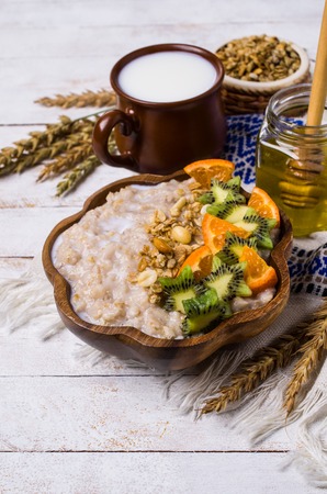 Oatmeal with fruit in a plate on the table. Selective focus.の写真素材