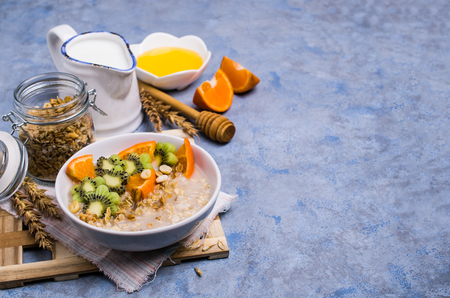 Oatmeal with fruit in a plate on the table. Selective focus.の写真素材