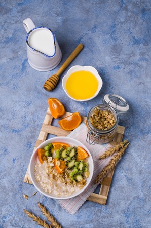 Oatmeal with fruit in a plate on the table. Selective focus.の写真素材