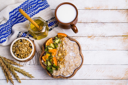 Oatmeal with fruit in a plate on the table. Selective focus.の写真素材