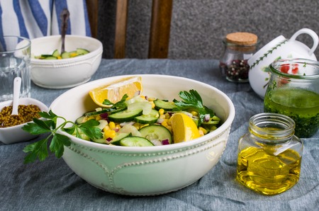 Salad with raw vegetables and corn in a plate on the table. Selective focus.の写真素材