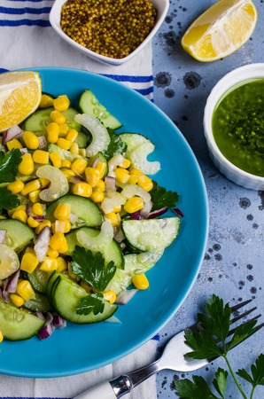 Salad with raw vegetables and corn in a plate on the table. Selective focus.の写真素材