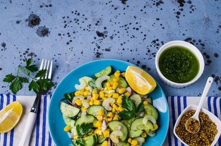 Salad with raw vegetables and corn in a plate on the table. Selective focus.の写真素材