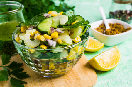 Salad with raw vegetables and corn in a plate on the table. Selective focus.の写真素材