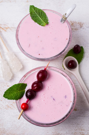 Cold dairy pink soup with berries in glass on the table. Selective focus.の写真素材