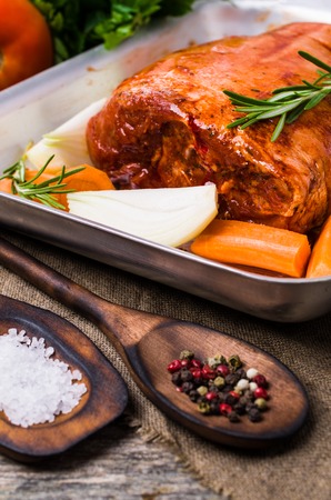 Raw pork knuckle in marinade with spices and vegetables. Selective focus.の写真素材