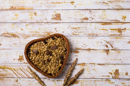 Dry oat flakes with raisins and chocolate in a dish on the table. Selective focus.の写真素材