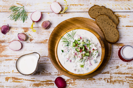 Traditional cold soup with vegetables in a plate on a wooden table. Selective focus.の写真素材