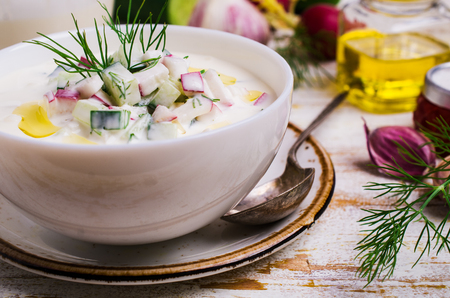 Traditional cold soup with vegetables in a plate on a wooden table. Selective focus.の写真素材