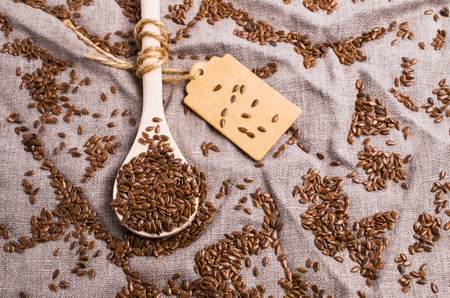 Seeds of pure brown flaxen in the tableware on the table with a cloth. Selective focus.の写真素材