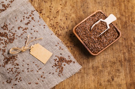 Seeds of pure brown flaxen in the tableware on the table with a cloth. Selective focus.の写真素材