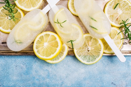 Frozen fruit ice with lemon and rosemary on a stick. Selective focus.の写真素材