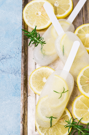 Frozen fruit ice with lemon and rosemary on a stick. Selective focus.の写真素材