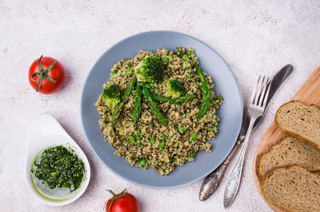 Vegetables with quinoa and green sauce in a dish on the table. Selective focus.の写真素材