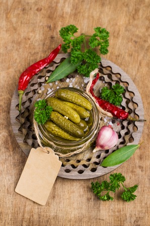 Pickled cucumbers with spices and parsley on a wooden background. Selective focus.の写真素材