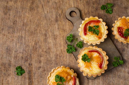 Tartlets with vegetables and cheese on wooden background. Selective focus.の写真素材