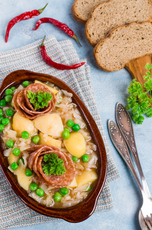 Salami with stewed vegetables in a dish on the table. Selective focus.の写真素材