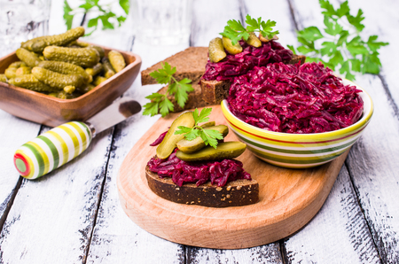 Sandwiches with beet and pickled cucumber on dark bread on a wooden background. Selective focus.の写真素材