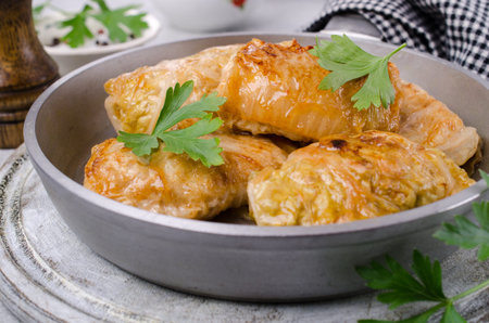 Fried stuffed cabbage in a frying pan on a stone background. Selective focus.