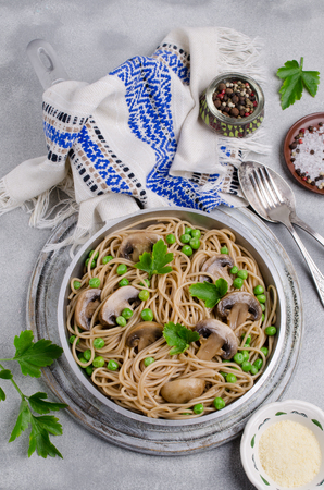 Dark pasta with mushrooms and peas on a slate background. Selective focus.の写真素材