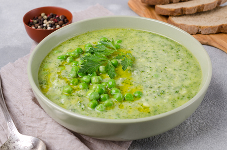 Vegetable cream soup with pesto sauce and parsley in a dish on the table. Selective focus.の写真素材