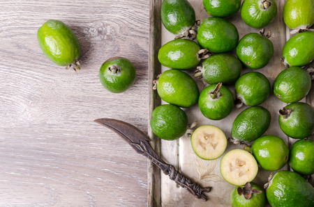 Fresh green feijoa in tableware on wooden background. Selective focus.の写真素材