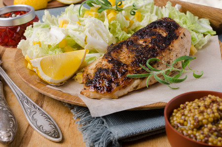 Fried chicken breast with spices and fresh vegetable salad. Selective focus.の写真素材