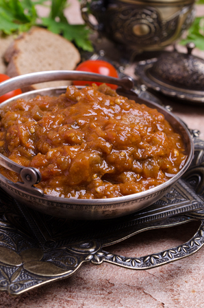 Traditional spicy stewed vegetables in a metal plate on the table. Selective focus.の写真素材