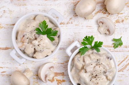 Slices of mushrooms and meat with white sauce on wooden background. Selective focus.の写真素材