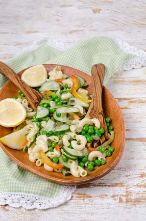 Salad with pasta and fresh vegetables on wooden background. Selective focus.の写真素材